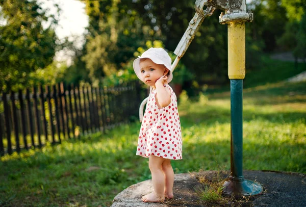 A toddler girl standing outdoors in garden in summer. — Stock Photo, Image
