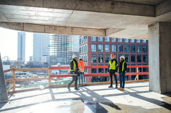 Группа инженеров, стоящих на строительной площадке, разговаривает . — стоковое фото