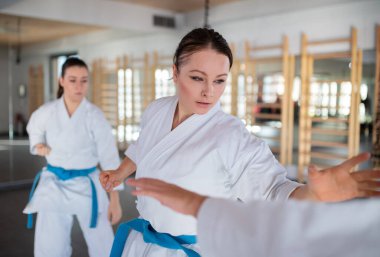 Spor salonunda karate yapan bir grup genç kadın..