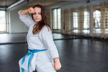 Spor salonunda karate yapan genç bir kadın..