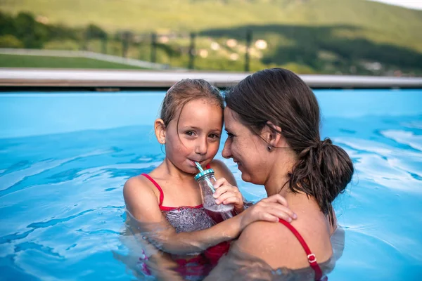 Mère avec petite fille dans la piscine extérieure . — Photo