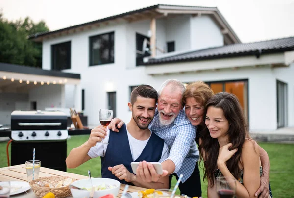 Porträt von Menschen im Freien beim Grillen im Garten der Familie, Selfie machen. — Stockfoto