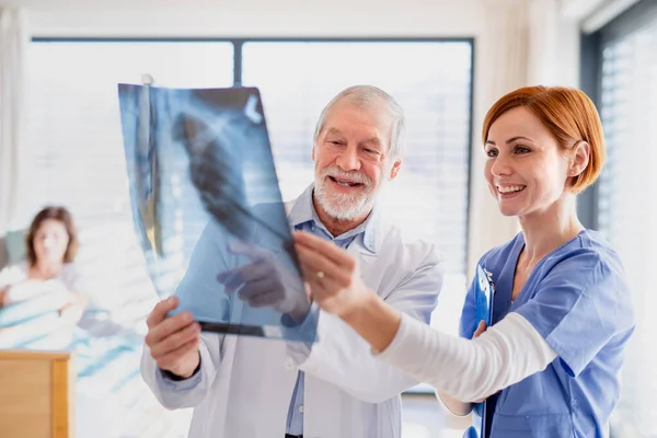 Médicos de pie en la habitación del hospital, examinando una radiografía . — Foto de Stock
