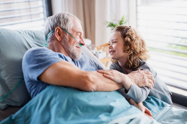 Small girl visiting ill grandfather in hospital room. — Stock Photo, Image