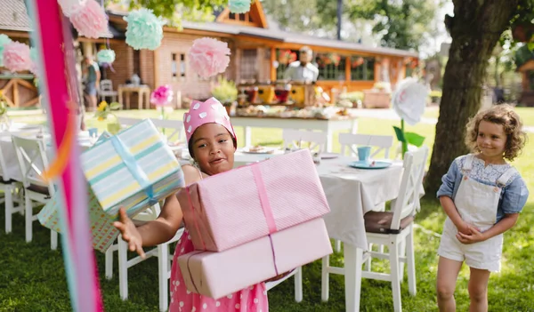 Ritratto di bambina con regali all'aperto in giardino in estate . — Foto Stock