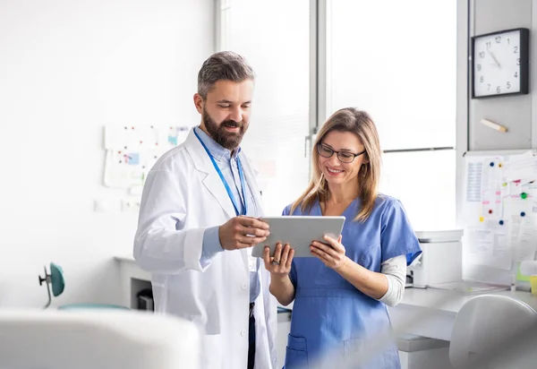 Un dentiste avec assistant dentaire en chirurgie dentaire moderne, travaillant . — Photo