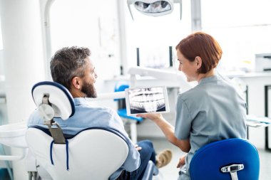 Diş cerrahisinde erkek ve dişçinin arka görünüşü, yıllık check-up.