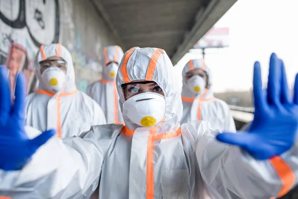 Люди з захисними костюмами та респіраторами на відкритому повітрі, концепція коронавірусу . — стокове фото