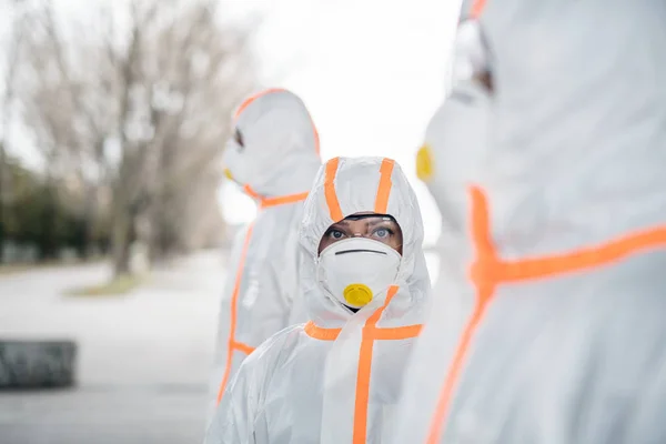 Люди з захисними костюмами та респіраторами на відкритому повітрі, концепція коронавірусу . — стокове фото