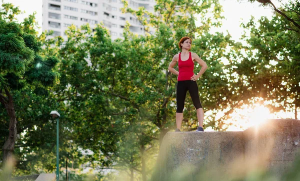 Junge Frau steht in der Stadt im Freien und ruht sich nach dem Sport aus. — Stockfoto