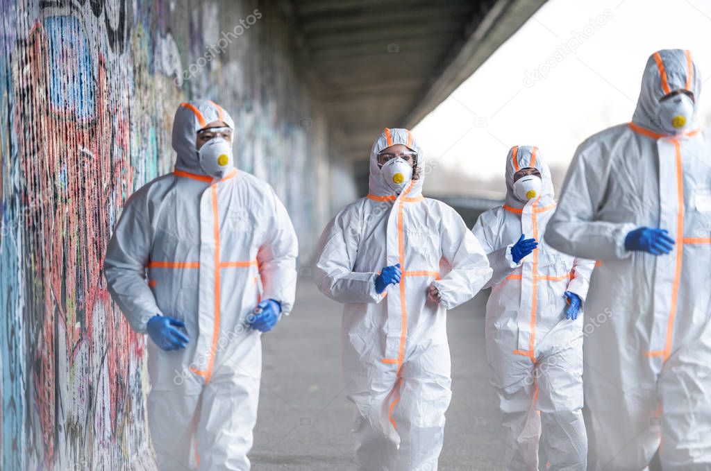 People with protective suits and respirators running outdoors, coronavirus concept.