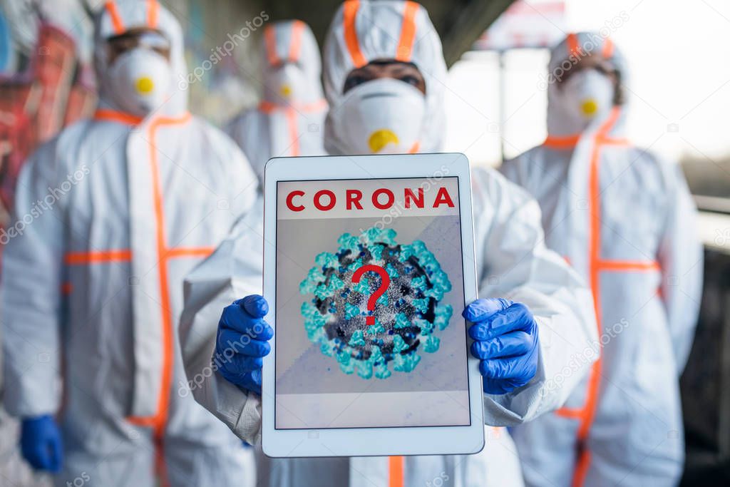 People with protective suits and respirators outdoors, coronavirus concept.