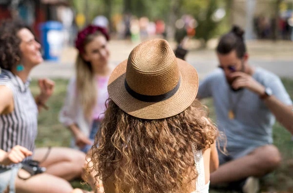 Groep jonge vrienden zit op de grond op zomerfestival. — Stockfoto