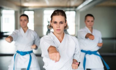 Spor salonunda karate yapan bir grup genç kadın..
