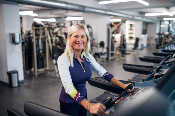 Une femme âgée au gymnase qui fait de l'exercice cardio . — Photo