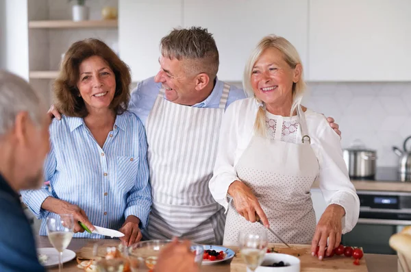 Gruppo di amici anziani a cena a casa, cucina . — Foto Stock