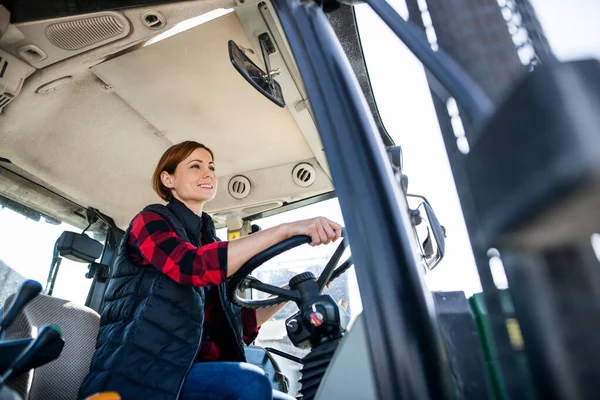 Kobieta pracownik jazdy ciągnika w gospodarstwie rolnym, przemysł rolniczy. — Zdjęcie stockowe