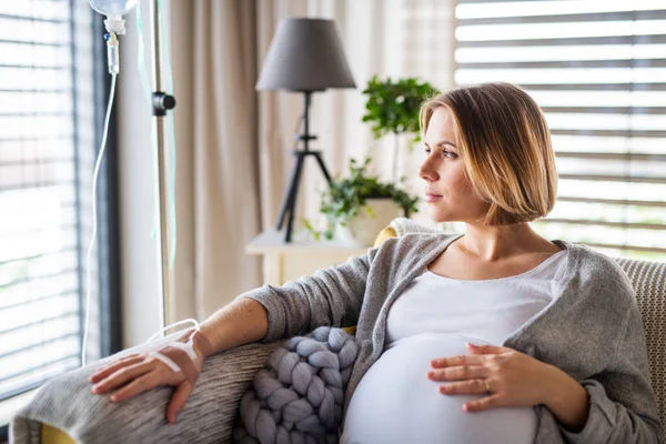 Retrato de una mujer embarazada con goteo intravenoso en el interior del hogar o en el hospital . — Foto de Stock