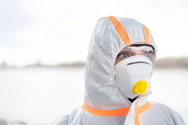 Femme avec combinaison de protection et respirateur debout à l'extérieur, concept de coronavirus . — Photo