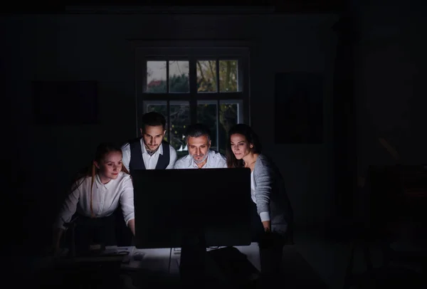 Groupe de gens d'affaires avec ordinateur à l'intérieur dans le bureau, travaillant tard . — Photo