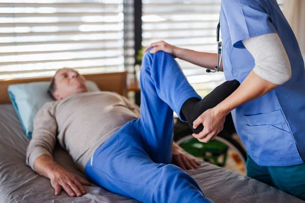 Um profissional de saúde e paciente idoso no hospital, fisioterapia . — Fotografia de Stock