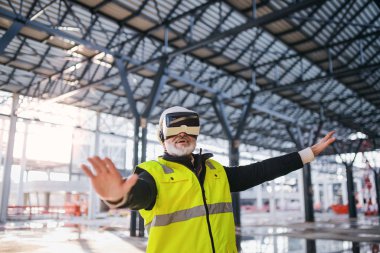 Man engineer using VR goggles on construction site.
