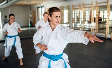 Spor salonunda karate yapan bir grup genç kadın..