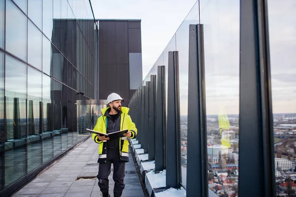 건축 현장을 걷고 있는 인간 기술자 청사진을 들고 있는 모습. — 스톡 사진