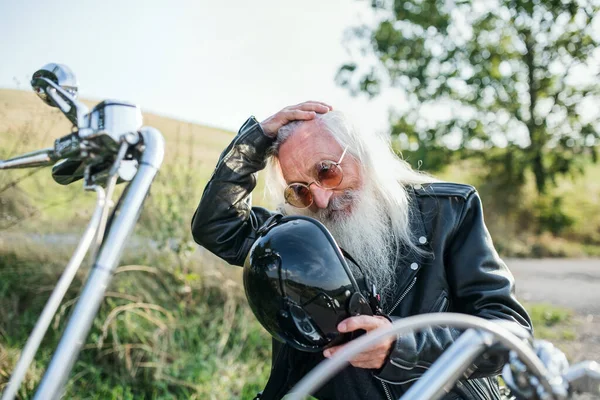 Un hombre mayor viajero con moto en el campo . —  Fotos de Stock