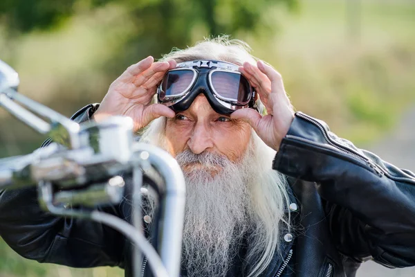 Un voyageur senior avec moto et lunettes à la campagne . — Photo