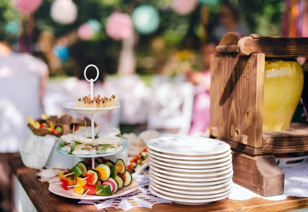 Food on table on kids birthday party outdoors in garden in summer. — Stockfoto