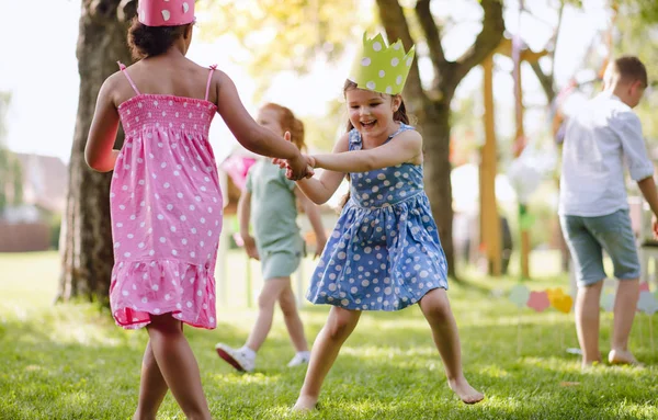 夏に庭に立って遊んでいる小さな子供たち. — ストック写真