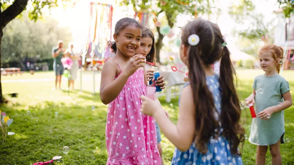 Kleine kinderen die in de zomer buiten in de tuin staan te spelen. — Stockfoto