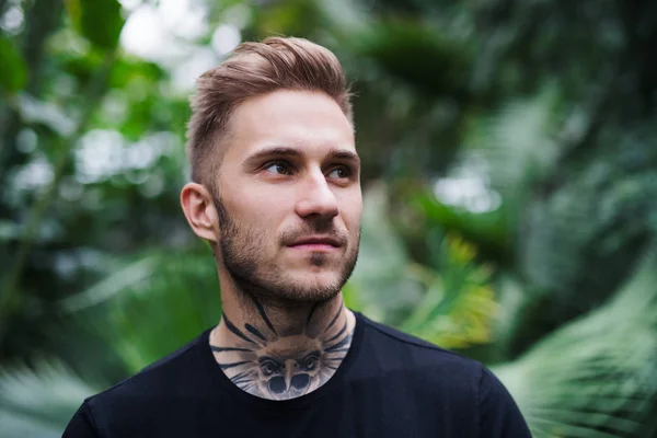 Front view of young man standing in botanical garden. — Stock Photo, Image