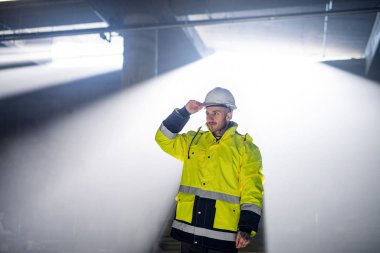 Man worker outdoors on construction site, working.