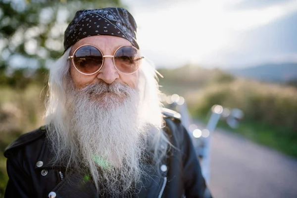 Senioren reiziger met motor en zonnebril op het platteland. — Stockfoto