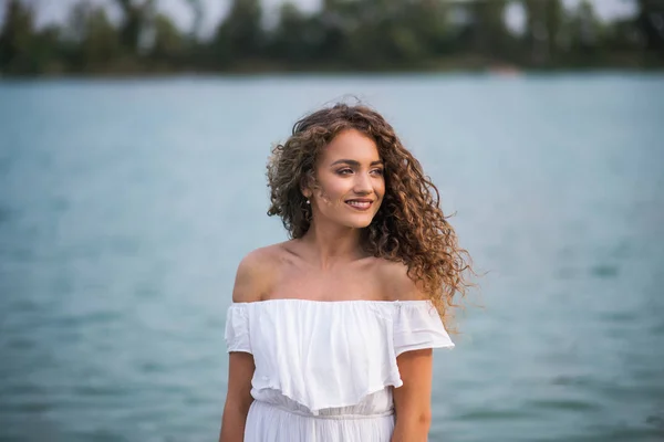 Front view of young woman at summer festival, standing in lake. — Stock Photo, Image