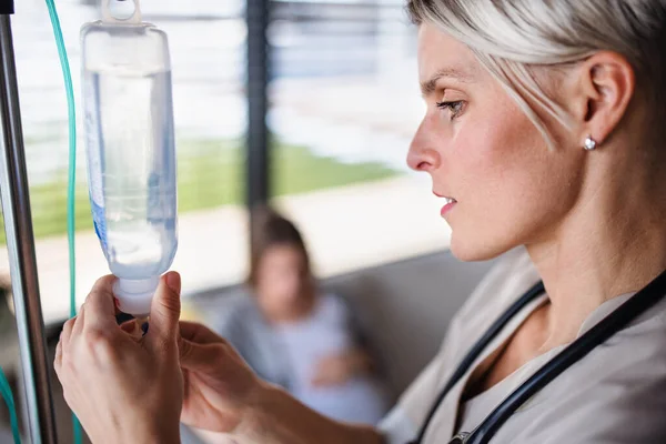 A nurse preparing IV drip in hospital or at home. — Stockfoto