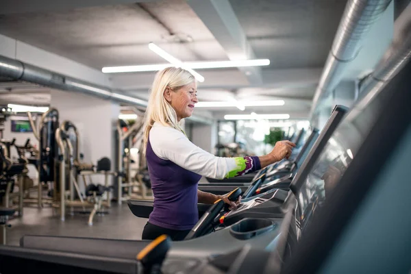 一位在体育馆里做有氧运动的老年妇女锻炼身体. — 图库照片