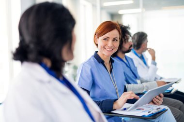 Group of doctors with tablet on medical conference, talking.