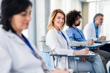 Tıp konferansında sunumu dinleyen bir grup doktor.