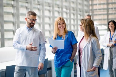 Bir grup doktor tıp konferansında koridorda yürüyor..