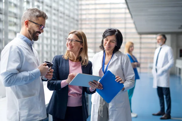 Group of doctors talking to pharmaceutical sales representative. — Stock Photo, Image