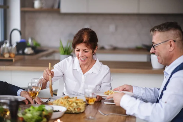 Grupo de amigos seniores no jantar em casa, comendo . — Fotografia de Stock