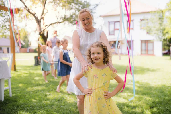 Nonna con piccola girll all'aperto sulla festa in giardino in estate, giocando . — Foto Stock
