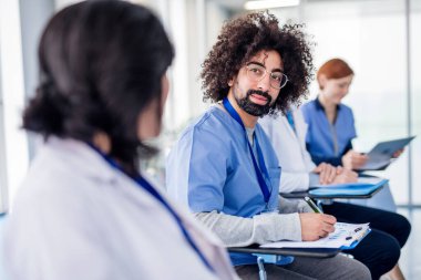 Group of doctors with tablet on medical conference, talking.