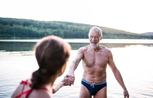 Senior couple in swimsuit standing in lake outdoors before swimming. — Stock Photo, Image