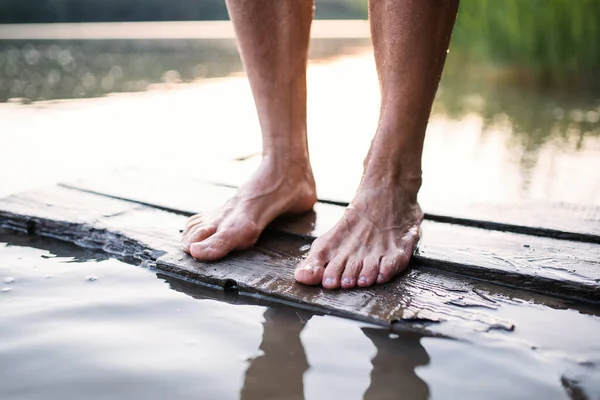 泳ぐ前に湖の外に立つ女性の裸の足. — ストック写真