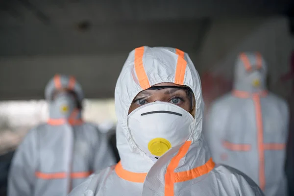 Menschen mit Schutzanzügen und Atemschutzmasken im Freien, Coronavirus-Konzept. — Stockfoto