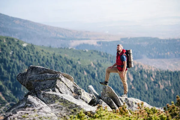 Homem maduro com mochila caminhadas nas montanhas no verão . — Fotografia de Stock